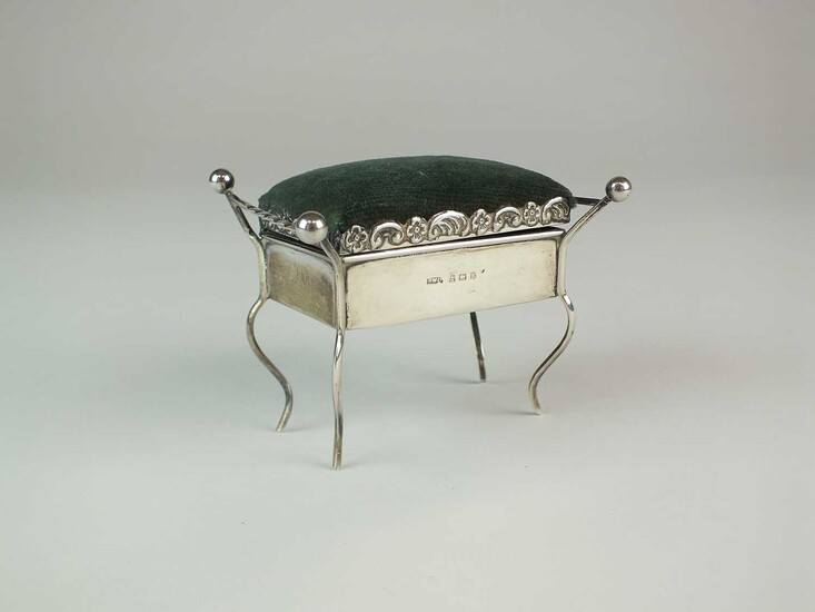 An Edwardian novelty silver pin cushion in the form of a piano stool