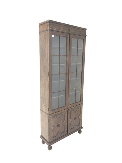 Early 20th century oak bookcase on cupboard, frieze with...