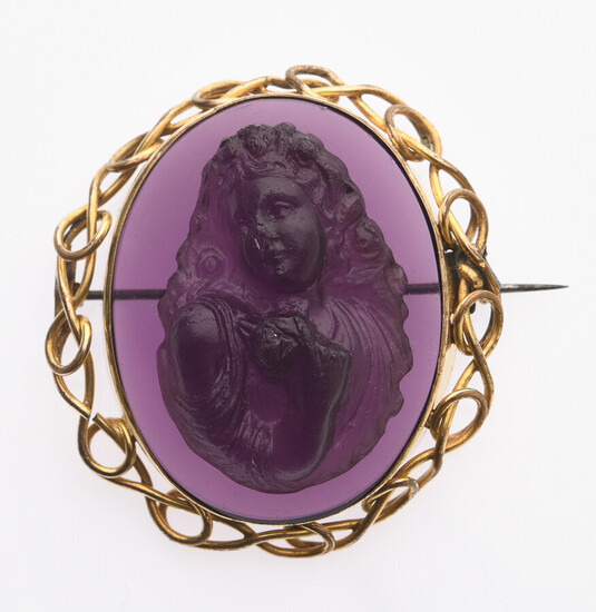 Lot 224 CAMEE sur verre violet à à décor d'une jeune femme, l'épaulé dénudée, tenant dans sa main une rose. monture en métal tressé. 4.9 x 4.4 cm.