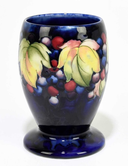 MOORCROFT; a 'Leaf and Berry' pattern vase, with a blue...