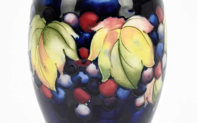 MOORCROFT; a 'Leaf and Berry' pattern vase, with a blue...