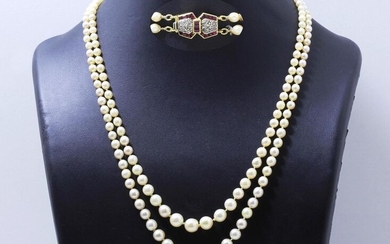 Necklace composed of 2 cultured pearl scraps of about 3.8 to 8.7 mm, adorned with a 750 gold and 850 platinum ratchet clasp with safety chain, dressed with diamond roses edged with calibrated rubies.
