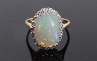 Opal and diamond cluster ring with an oval cabochon opal surrounded by 20 single cut diamonds on 18ct gold shank