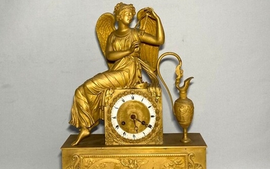 PENDULE en bronze doré représentant Iris s'attachant les ailes, assise sur une borne près d'une...