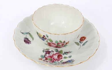 Worcester fluted tea bowl and saucer, circa 1772, polychrome painted with flowers, with gilt rims, the saucer measuring 13.5cm diameter