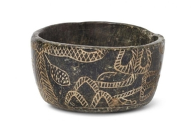 An black stone bowl with incised palm...
