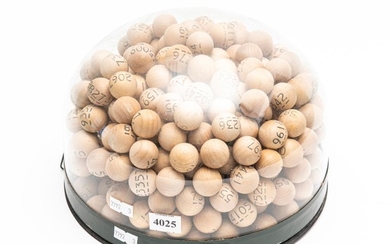 A GLASS DOMED DISPLAY CONTAINING WOODEN LOTTERY BALLS