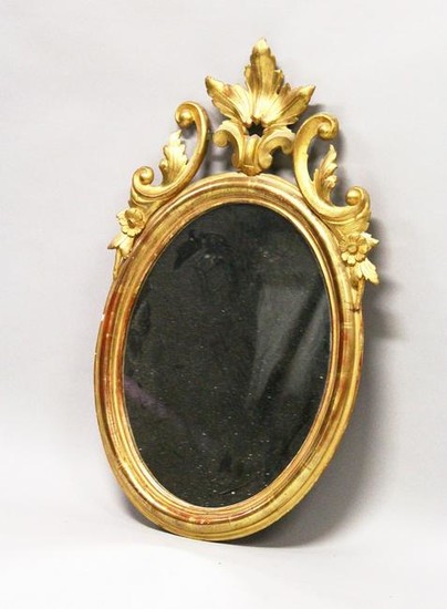 A 19TH CENTURY OVAL GILT FRAMED MIRROR, with carved