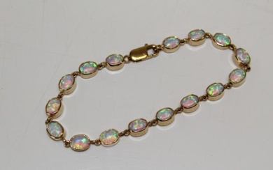 A 9ct yellow gold opal line bracelet, set with 16...