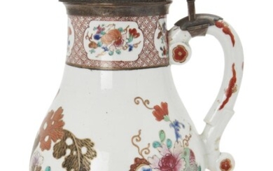A Chinese famille rose silver-mounted baluster jug, Qianlong period, painted with flowering shrubs beneath a brown diaper neck, the German silver-gilt hinged cover engraved with a coat-of-arms, the rim mounts hall-marked for London, 1859, 30cm high...