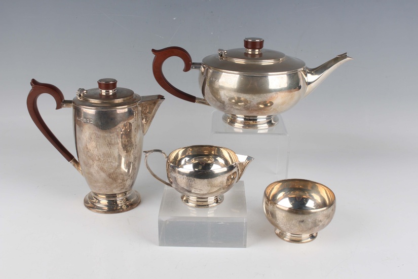 A George V silver four-piece tea set of squat circular form, comprising teapot, hot water pot, sugar