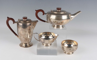 A George V silver four-piece tea set of squat circular form, comprising teapot, hot water pot, sugar
