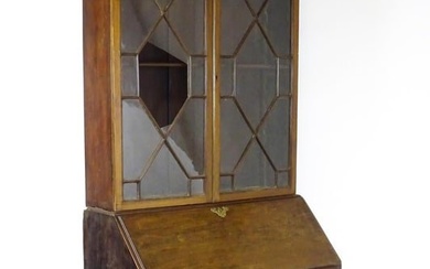 A Georgian mahogany bureau bookcase, with a moulded top above two astragal glazed doors and a fall