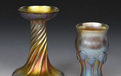 A Louis Comfort Tiffany Favrile glass vase, twisted form with flaring top rim, and another Louis Comfort Tiffany glass vase with applied prunts with trails, applied paper label to top rim, etched L.C.T, losses to one trail on second vase, 12.5cm. high...