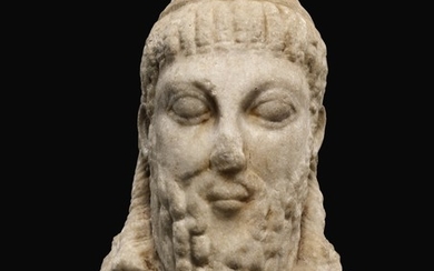 A ROMAN MARBLE ARCHAISTIC HERM HEAD OF DIONYSOS, CIRCA 2ND CENTURY A.D.