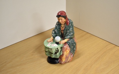A Royal Doulton bone china figurine 'Fortune Teller' modelled seated at a table with crystal ball