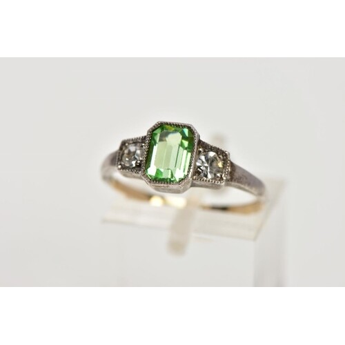 A YELLOW AND WHITE METAL DRESS RING, centring on an emerald ...