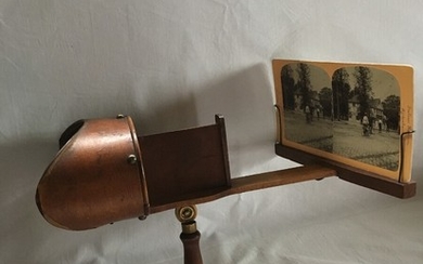A circa 1900 wooden streoscope and two boxes with stereoscopic slides. H. c. 15 cm. (3)