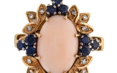 A coral, sapphire and diamond ring, of cluster design, centring on an oval coral corallium rubrum cabochon, within a leaf surround accented with circular-cut sapphires and single-cut diamonds, c. 1960 ring size P