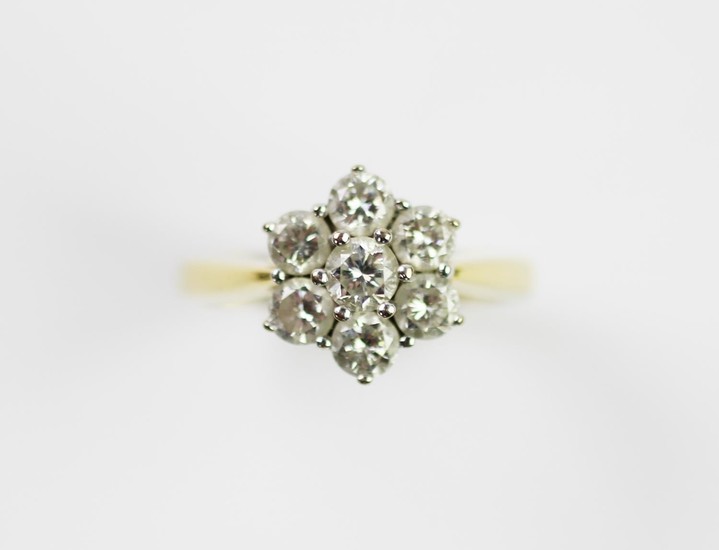 A diamond set cluster ring, designed as a central claw set b...