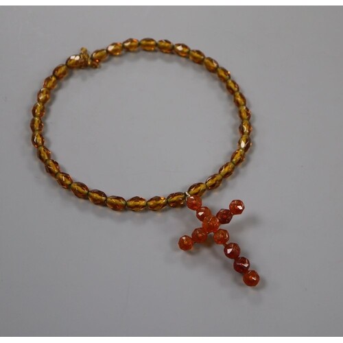 A gilt metal and facet cut amber set cross pendant, 6cm, on ...