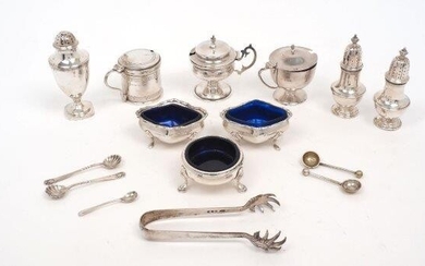 A group of silver cruets comprising: a George III pepper shaker, London, 1788, maker's mark rubbed; a George III silver salt with blue glass liner, London, 1768, George Smith (II); a pair of baluster shaped pepper shakers, Birmingham, 1929, Mappin...