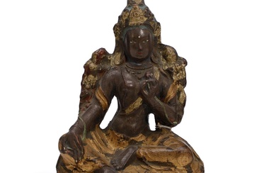 A painted and gilt terracotta figure of Green Tara seated on a...
