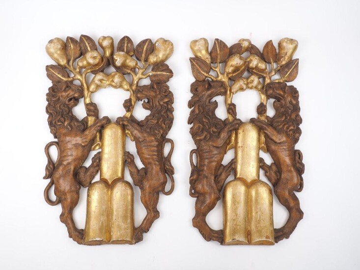 A pair of Italian carved and giltwood wall carvings, 19th century, each with a pair of lions holding fruiting branches, 61cm high (2)