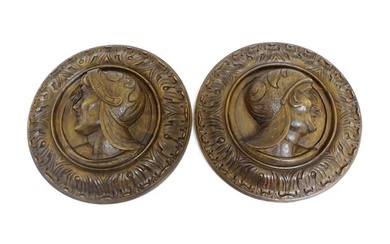 A pair of late 19th / early 20thC carved walnut roundels depicting stylised warriors / soldiers to
