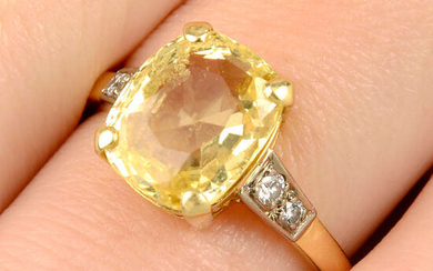 A yellow sapphire single-stone ring, with brilliant-cut diamond shoulders.