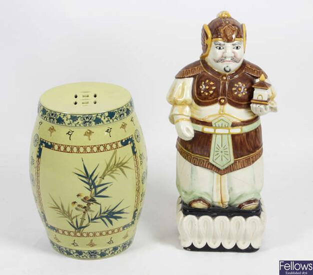 An Oriental pottery garden seat of pierced barrel form, together with a large pottery figure.