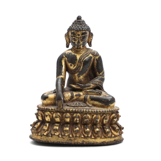 An early 18th century Nepali gilt bronze figure of Buddha Shakyamuni, seated...