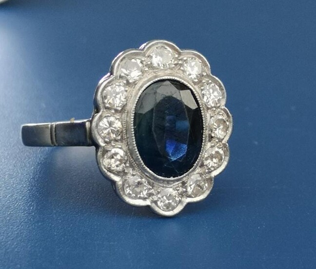 An oval sapphire & diamond millegrain set cluster ring,...