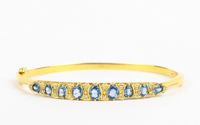 BRACELET Rigid, 18k gold with 18 natural diamonds of about 0.01 ct each and synthetic sapphires, stamped Peter Gilmore Ltd London 1900 century.