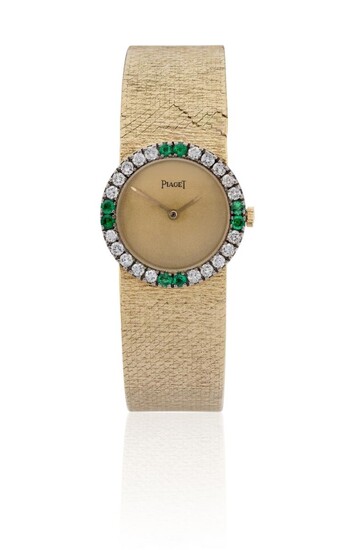 Beuche-Girod. A lady's diamond and emerald set bracelet watch, dial signed Piaget, Circa 1960 with champagne coloured dial signed Piaget, gold baton hands, 17-jewel manual wind movement, 18ct gold case with diamond and emerald pavé set bezel...