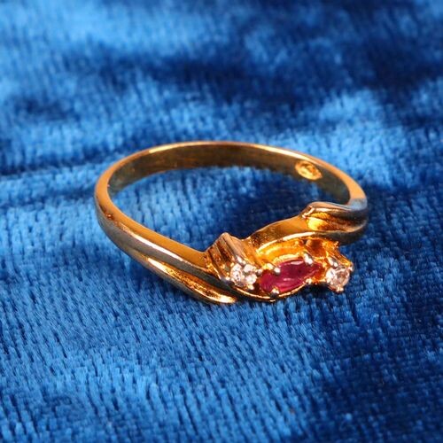 Gold-plated metal ring, decorated with a ruby supported by two...