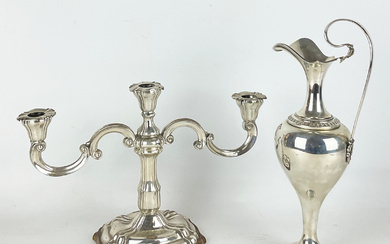 Lotto in argento composto da versatoio ad un'ansa mossa con foglie agli attacchi (h. cm 34,5) (g 400) e candelabro…