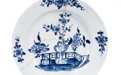 Lowestoft plate, painted in blue with a flowering plant and rockwork within a fenced enclosure, four floral sprays in the border, 22.8cm diameter