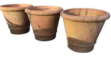 Three large tapering garden pots with cushion moulded rims,...