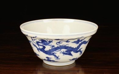A Chinese Blue & White Bowl decorated with two celestial dragons amongst wispy clouds on a raised fo