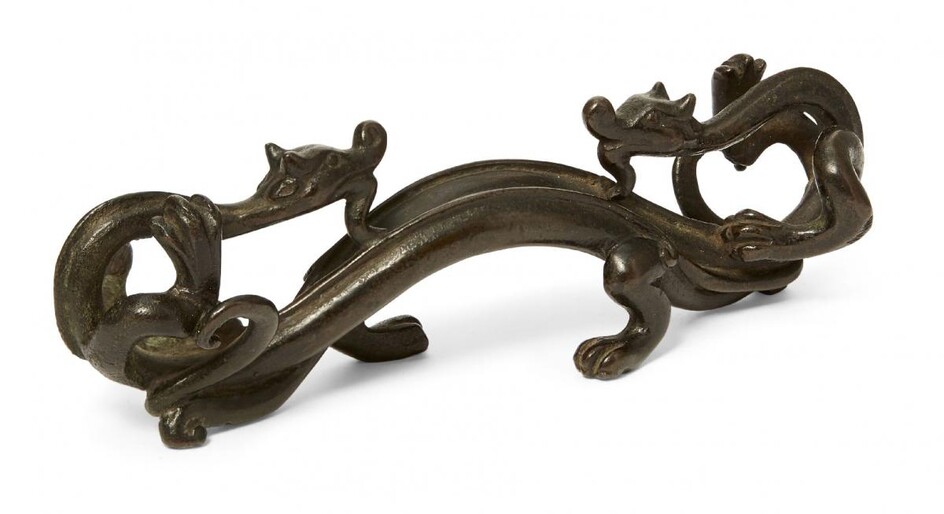 A Chinese bronze 'chilong' brush rest, Ming dynasty, 17th century, cast as a pair opposing chilong dragons with horned snouts, supported on their hind legs and tails, 18cm long