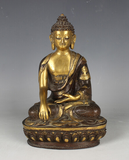 A Sino-Tibetan brown patinated and parcel gilt bronze figure of Buddha, modelled seated in dhyanasan