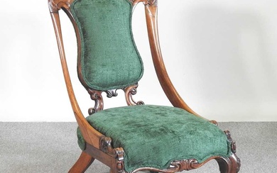 A Victorian carved walnut and green upholstered nursing chair, on...