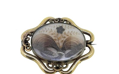 A Victorian memorial brooch, oval glazed compartment containing neatly woven hair and seed pearls