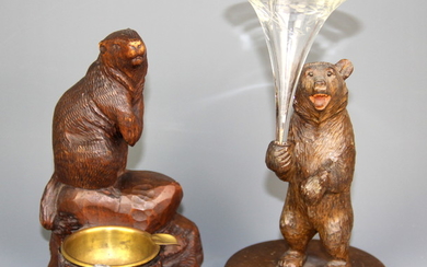 A carved Black Forest inkwell figure of a beaver, together with a further Black Forest carved wooden figure of a bear holding a glass bud va