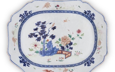 A large Chinese blue and white and famille rose meat platter, 18th century, painted with tree, rock, birds and flowers to the centre, encircled by a band of diaper, the rim with a border of alternating birds and flowerheads, base glazed, 33x42cm...