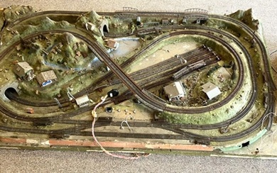 A large vintage trainset diorama, with various tunnels, buildings and landscaping, set on a board