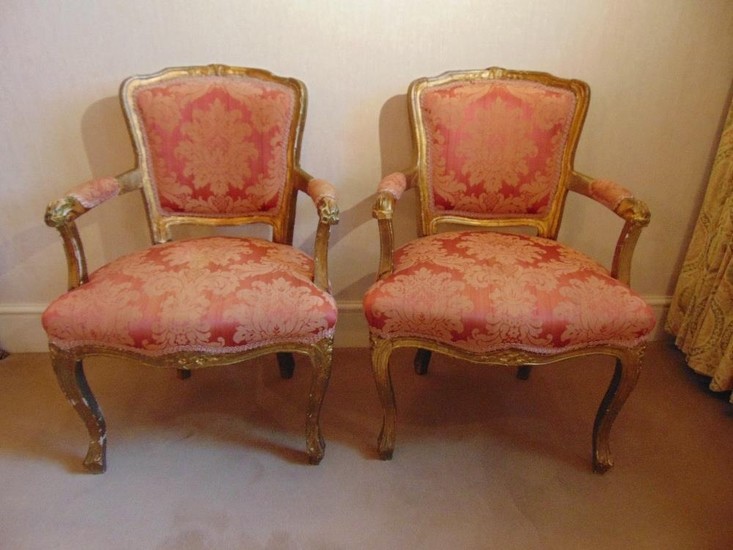 A pair of French upholstered bedroom armchairs on cabriole l...