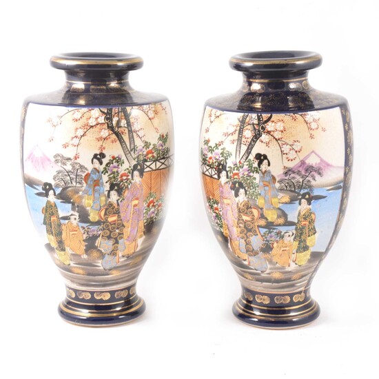 A pair of Japanese Satsuma shouldered vases decorated with two panels of colourful figures in a garden.