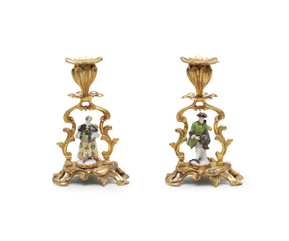 A pair of ormolu candlesticks mounted with miniature Meissen figures, the porcelain mid-18th century